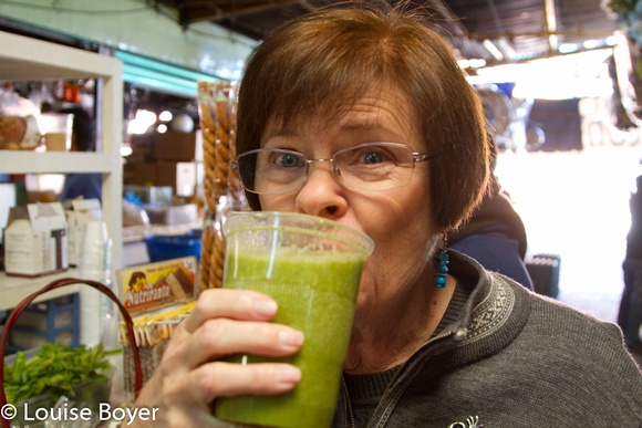 Louise toma un jugo verde rico preparado con verduras frescas.
