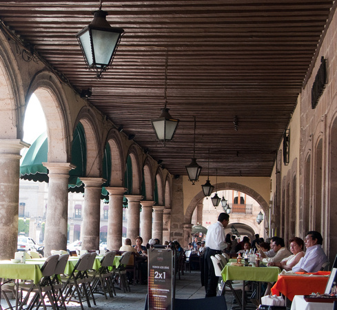 Sidewalk cafés beneath the arches across from the cathedral.-- Les cafés-terrasses s'alignent sous les arches devant la cathédrale.